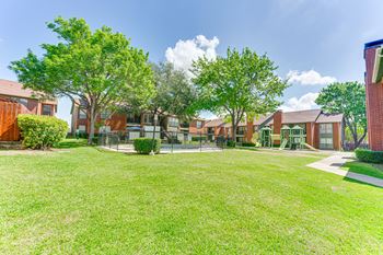 A grassy area in front of a row of houses.